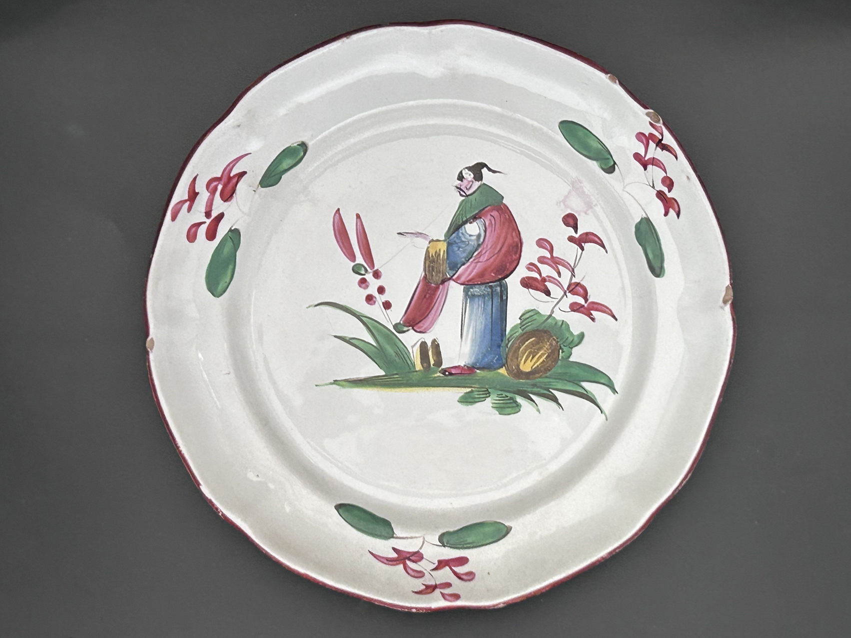 Assiette avec un personnage , Faïencerie des Islettes, XIXe : Assiette au décor polychrome avec un chinois dans un décor floral - XIXe siècle