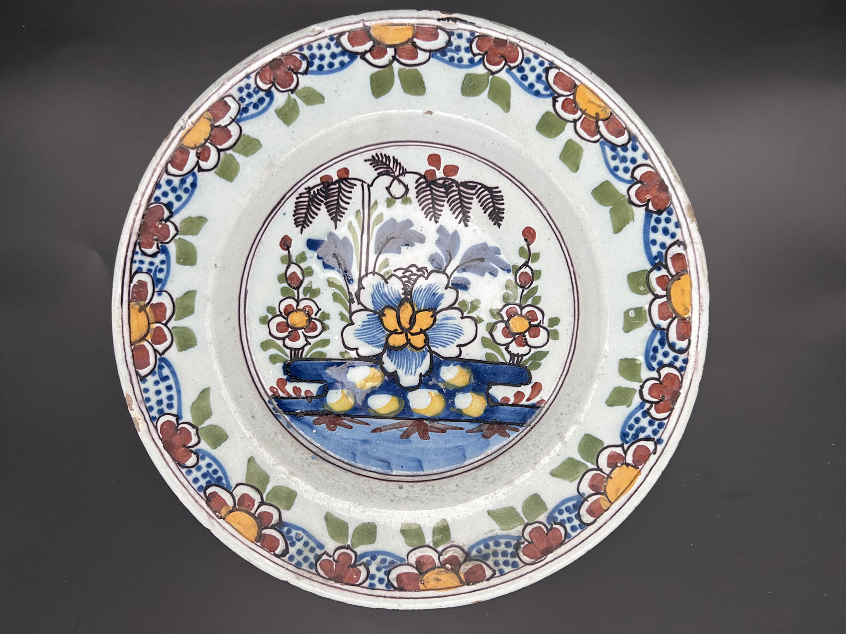 Assiette artisanale ancienne de Desvres 1780-1820 : Assiette artisanale ancienne représentant un panier fleuri, vers 1780-1820, Desvres Nord de la France