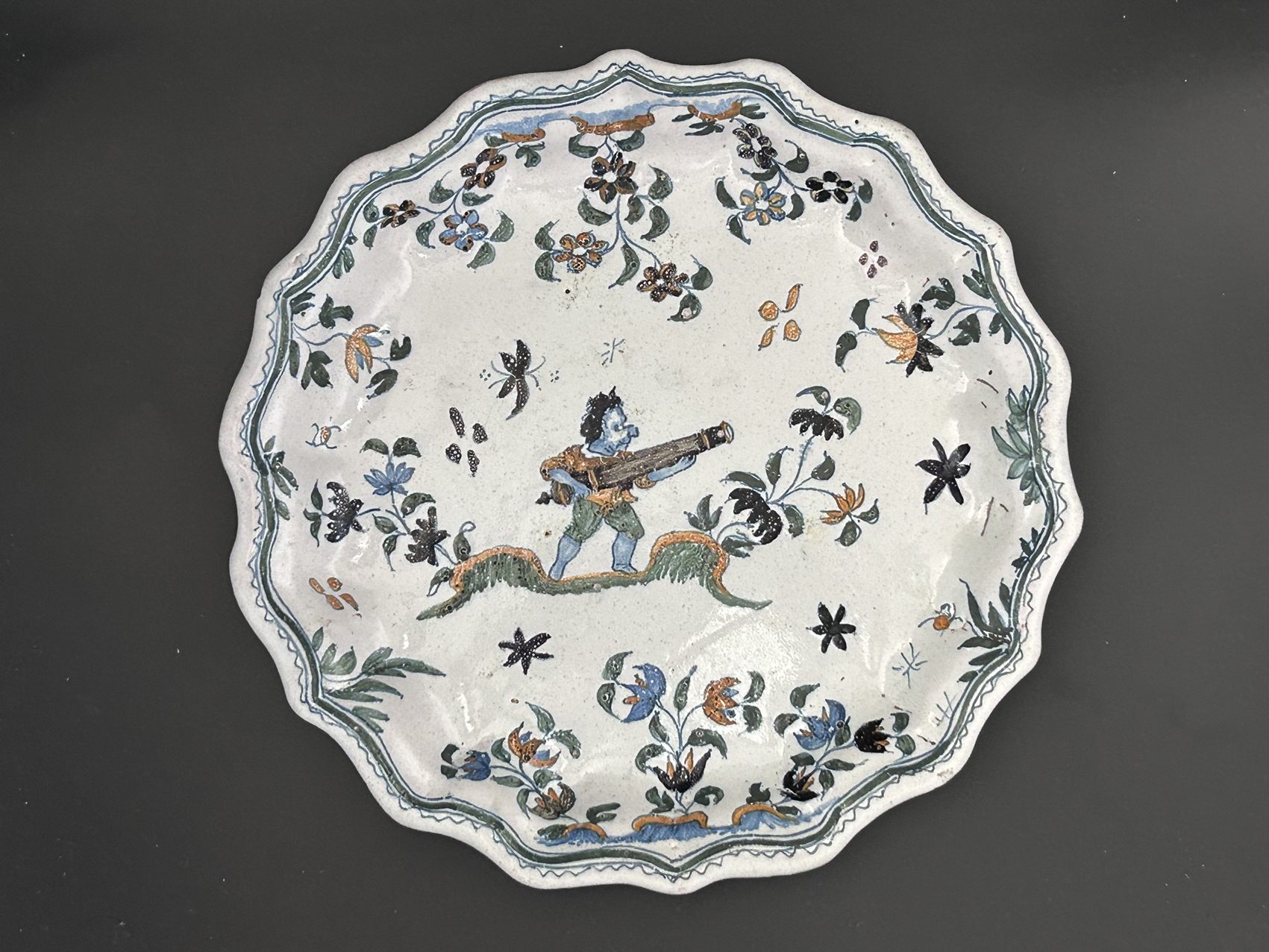 Rare assiette de Moustiers du XVIIIe au décor grotesque